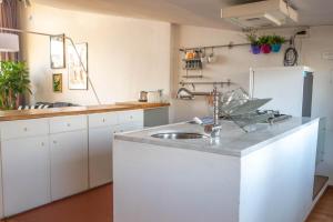 una cucina bianca con lavello e frigorifero di Santa Croce Flat Amazing View a Firenze Altre 21 foto