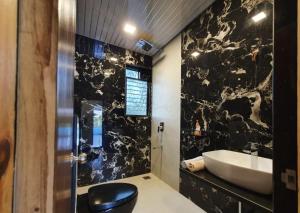 a bathroom with a sink and a toilet and a tub at Lake Side Mantra in Khamshet +23 photos