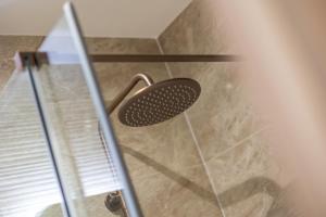 een glazen douchedeur met een douchekop bij Leeds City Centre Luxe Flats 8 mins to Station! in Central Station