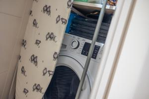 een wasmachine in een kamer met een gordijn bij Leeds City Centre Luxe Flats 8 mins to Station! in Central Station