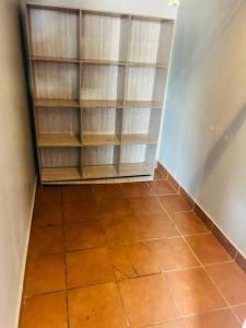 un armadio con ripiani in legno e pavimento piastrellato di Alena's Cozy bunk beds a Durban