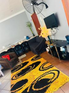 un soggiorno con un tappeto giallo e nero di Alena's Cozy bunk beds a Durban Altre 6 foto