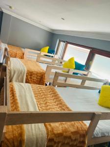 una camera con un sacco di letti e finestre di Alena's Cozy bunk beds a Durban