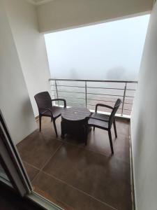 a balcony with two chairs and a table at Zeenus Holiday Resort in Yercaud