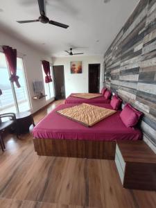 a bedroom with two beds with pink pillows at Zeenus Holiday Resort in Yercaud