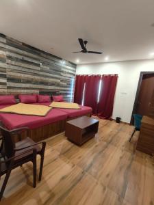 a room with two beds and a table in it at Zeenus Holiday Resort in Yercaud +5 photos