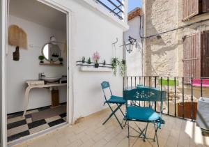 Una habitación con dos sillas y una mesa en un balcón. en Les Terrasses de Choubaka, en Alignan-du-Vent