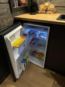 a refrigerator with its door open in a kitchen at Shaman Village - Resort & Glass Igloos in Rovaniemi