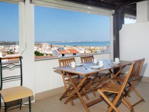 una mesa y sillas en un balcón con vistas en Apartment in Lagos en Lagos