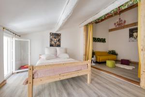 Un dormitorio con una cama y una sala de estar. en Les Terrasses de Choubaka, en Alignan-du-Vent