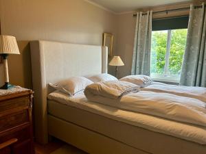 un letto con lenzuola e cuscini bianchi in una camera da letto di Mikkelsby house by Altafjord ad Alta