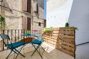 Un patio con dos sillas y una mesa en un balcón. en Les Terrasses de Choubaka, en Alignan-du-Vent