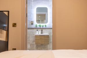a bathroom with a sink and a mirror at Leeds City Luxe Apartment with Parking, 8 mins to station! in Central Station