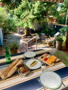 a table with plates of food on top of it at La Bigotière avec clim et jardin in Arles