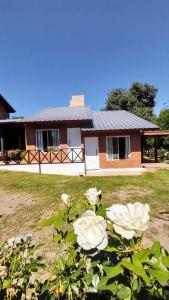 ein Haus mit weißen Rosen davor in der Unterkunft Cabañas Santa Isabel in Santa Rosa de Calamuchita + 31 Fotos