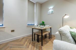 a living room with a table and a couch at Leeds City Luxe Apartment with Parking, 8 mins to station! in Central Station