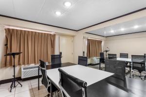 ホフマンエステーツにあるRed Roof PLUS Chicago - Hoffman Estatesのカーテンのかかった部屋にテーブルと椅子が置かれた会議室