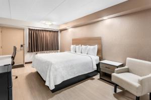 ホフマンエステーツにあるRed Roof PLUS Chicago - Hoffman Estatesのベッドと椅子のあるホテルの部屋 +34枚の写真