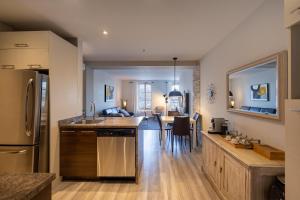 a kitchen and living room with a refrigerator freezer at Les Immeubles Charlevoix - Le 1175 in Quebec City