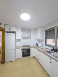 cocina con armarios blancos, fregadero y nevera en Apartamento San Diego 1 - Almyra Inmobiliaria, en Los Alcázares