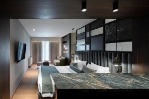 a bedroom with a large bed and a living room at The Stanley in Athens