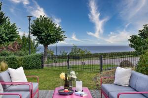 eine Terrasse mit 2 Stühlen und einem Tisch mit Meerblick in der Unterkunft Ferienwohnung Luxus Apartment MeerFreude Sellin in Ostseebad Sellin