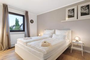 ein weißes Schlafzimmer mit einem großen weißen Bett und einem Fenster in der Unterkunft Mergl's in Bad Schonborn