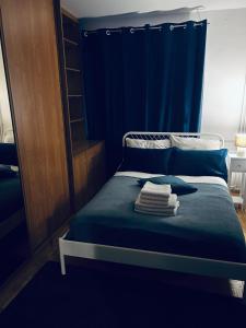 een slaapkamer met een blauw bed met handdoeken erop bij Włocławek Norwida in Włocławek