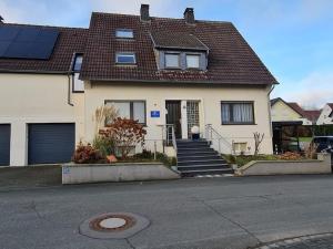 une maison blanche avec un toit marron dans l'établissement Ferienwohnung Sonnenring, à Heide