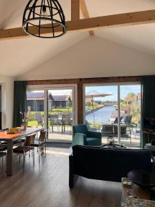 a living room with a table and chairs and a large window at Lauwershuisje, Sauna, Harbour Lauwersmeer in Anjum