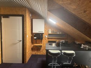 a kitchen with a sink and a counter with stools at The Loft in Lurgan