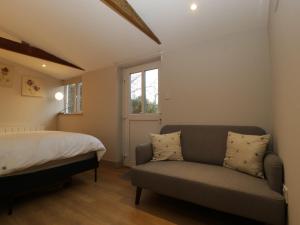 a bedroom with a couch and a bed and a window at The Hive in Bream