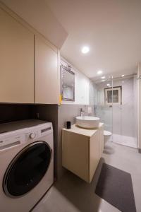 a bathroom with a washing machine and a sink at Villa Martina in Komiža