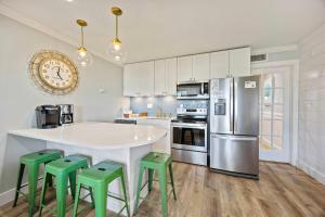 een keuken met een wit aanrecht en groene krukken bij Oceanfront Sunrises on Mitchelville Beach in Hilton Head Island