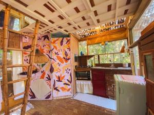 una cucina in una casetta minuscola con frigorifero di Cabana Floresta Amada a Ouro Preto Altre 19 foto