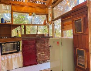 a kitchen with a refrigerator and a sink at Cabana Floresta Amada in Ouro Preto