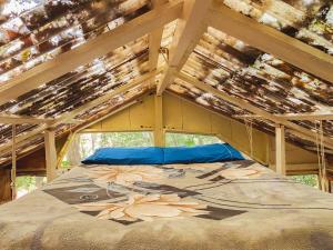 un grande letto in una stanza di legno con un tetto di legno di Cabana Floresta Amada a Ouro Preto