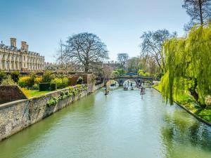 einen Fluss mit Brücke und Booten darin in der Unterkunft Rookery Cottage in Little Staughton