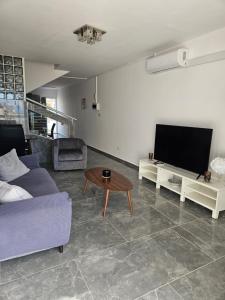 een woonkamer met een bank en een tafel bij Anton Luxury Villa SeaView by Emmelia Group in Klorakas