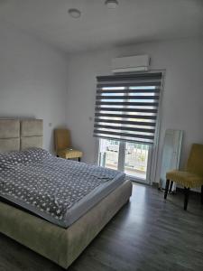 een slaapkamer met een bed en een raam met een blinde bij Anton Luxury Villa SeaView by Emmelia Group in Klorakas +4 foto's