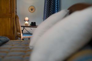 Soulosse-sous-Saint-ÉlopheにあるDessine moi un mouton, chambre d'hôte à Soulosseのベッドとランプ付きのテーブルがある寝室