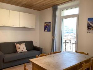 a living room with a table and a couch and a window at Fuga dalla città in Grosotto