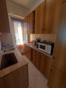 a kitchen with wooden cabinets and a white microwave at Il Maggiolino Mountain Apartment in Sondalo +9 photos