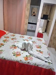 ein Bett mit einer Decke mit einem Schwan darauf in der Unterkunft Casa da Dil in Matta de São João