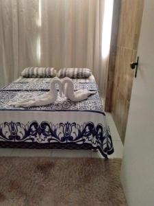 zwei Schwäne auf einem Bett in einem Zimmer in der Unterkunft Casa da Dil in Matta de São João