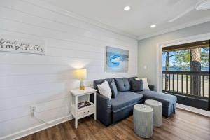 een woonkamer met een blauwe bank en een raam bij Unspoiled Beachfront Villa Sunrises from Balcony in Hilton Head Island