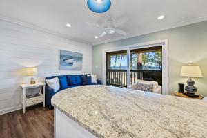 een woonkamer met een blauwe bank en een tafel bij Unspoiled Beachfront Villa Sunrises from Balcony in Hilton Head Island