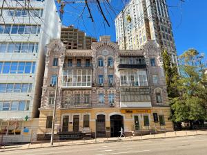 an old building on a city street with tall buildings at Kyiv White Apartment in Kyiv