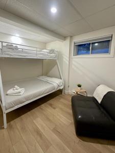 a room with two bunk beds and a couch at Chalet «L'Autrichien» de Charlevoix in Petite-Rivière-Saint-François