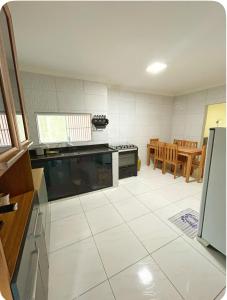 a kitchen with a large white tiled floor at Casa Maragogi in Maragogi +5 photos